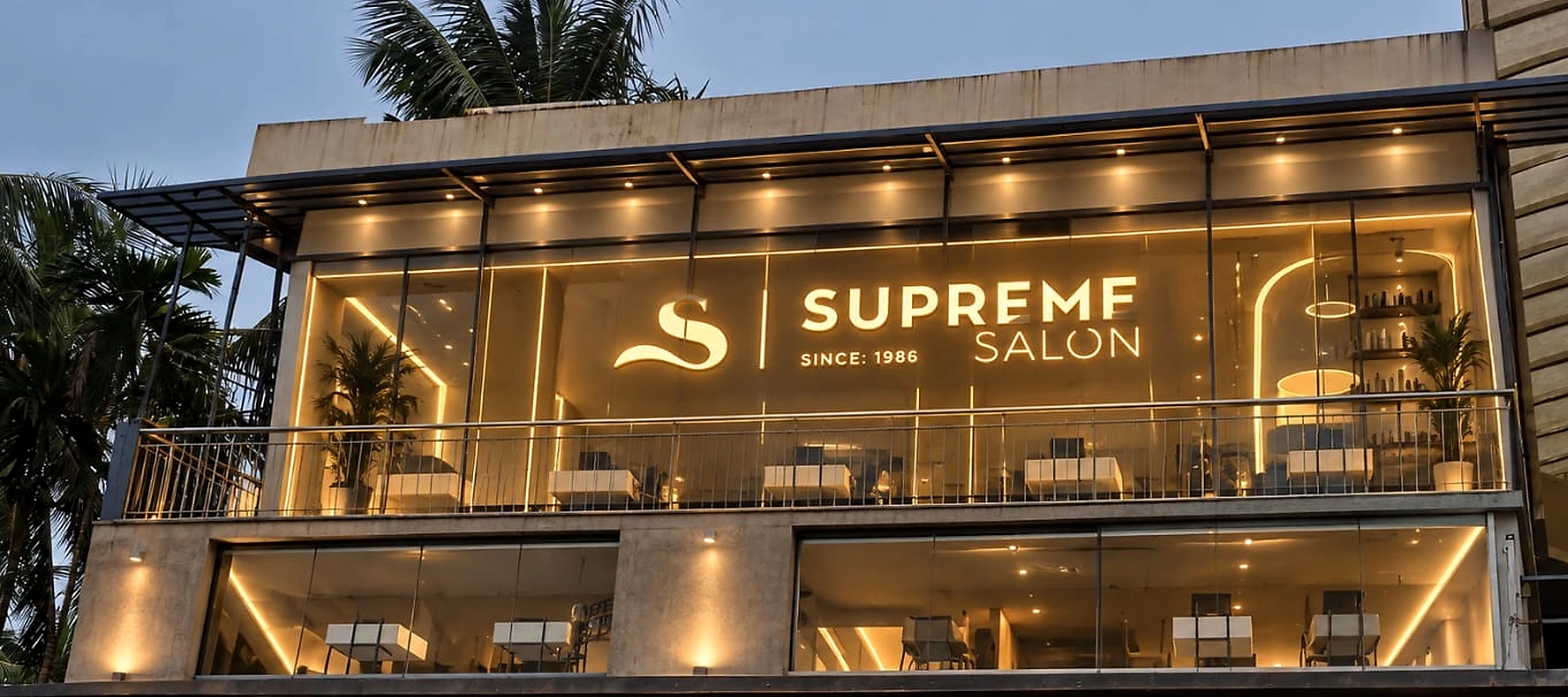 Illuminated Supreme Salon Kuthuparamba exterior at dusk